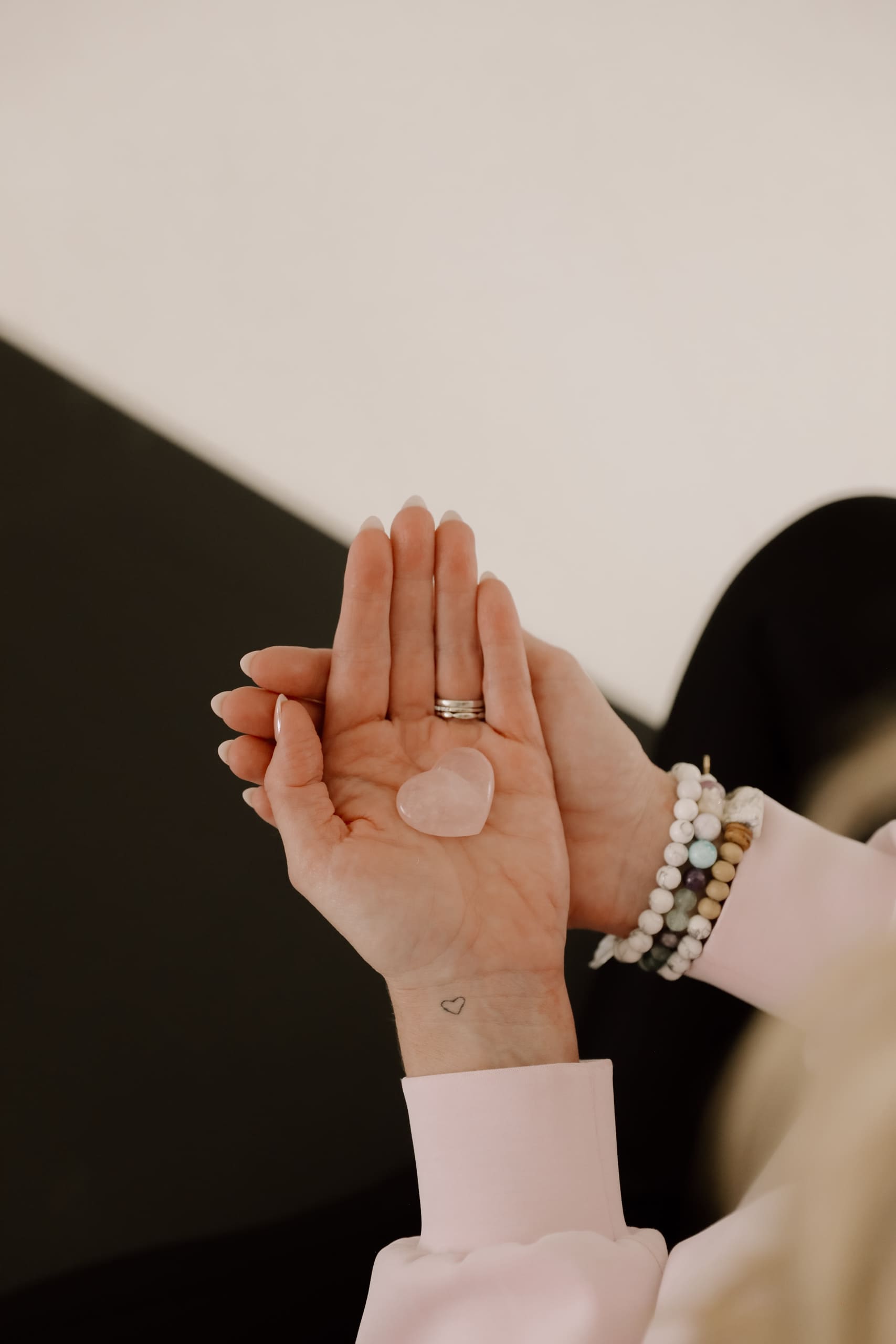 Woman holding rose quartz crystal in open palm, symbolizing emotional healing and inner work after divorce