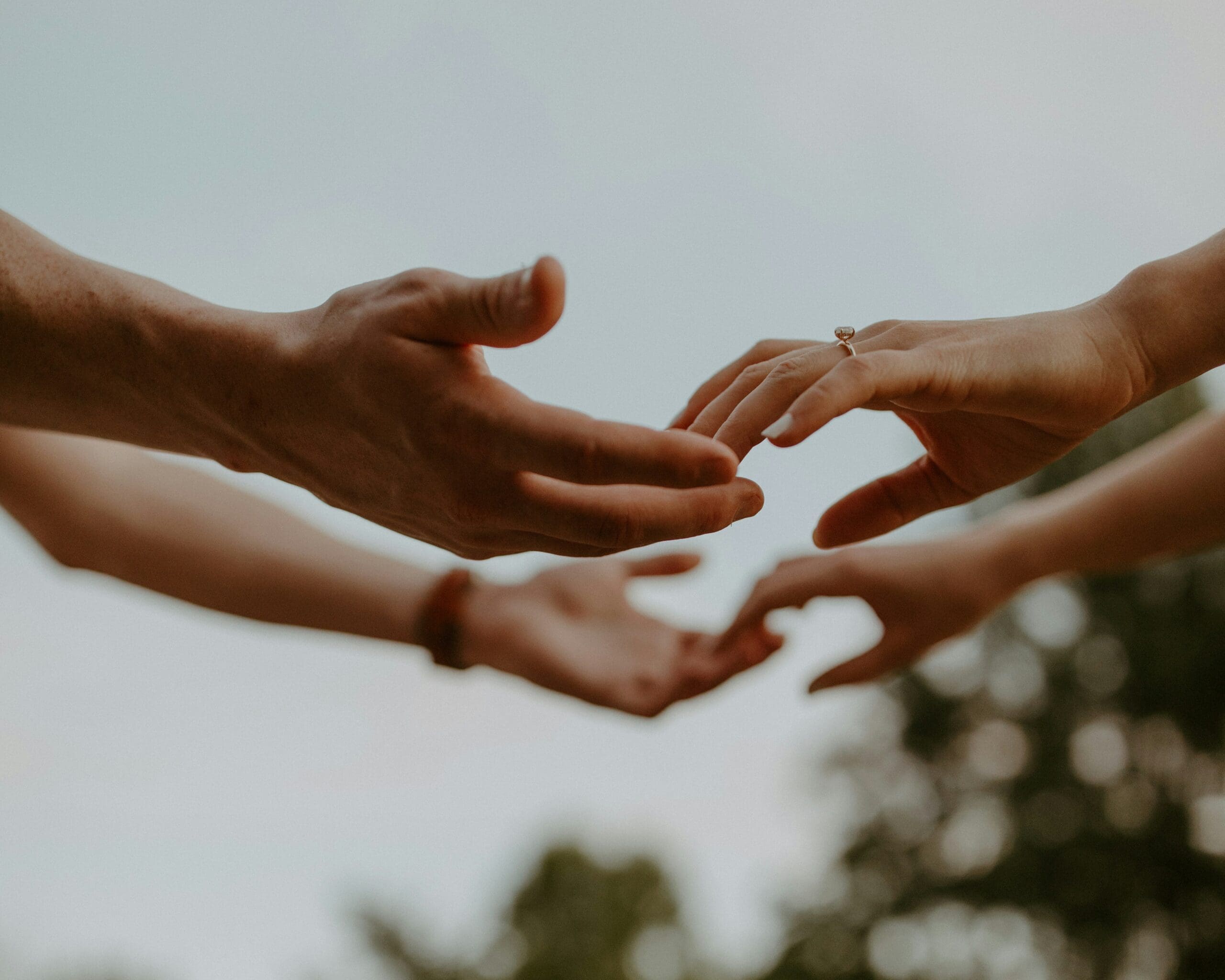 Two hands grabbing for each other outside
