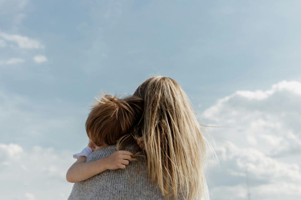 Mother holding child in comforting embrace, symbolizing emotional strength and safety in co-parenting after divorce